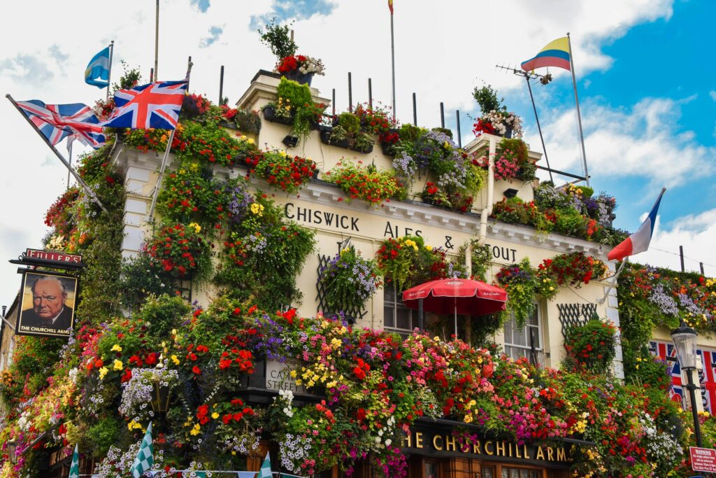 The Churchill Arms, a famous pub in London, known for its charming exterior adorned with flowers and festive decorations.