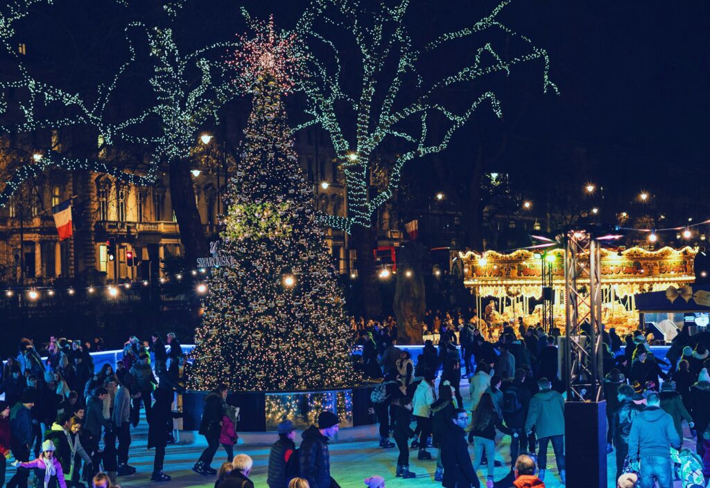 At night, the Christmas tree is beautifully lit up in Trafalgar Square, with people skating nearby